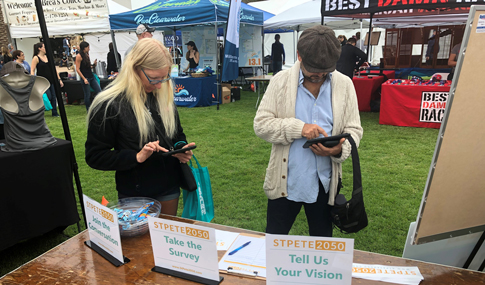 During a community event, residents complete a digital survey on the future of St. Petersburg.