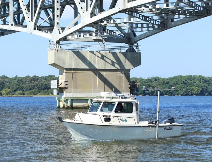 A hydrographic survey boat cruising on a river.