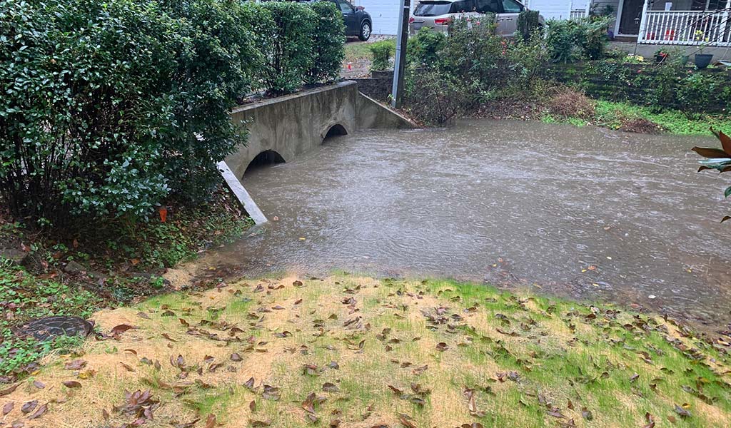 Endwall structure filling with flood waters in residential front yard.