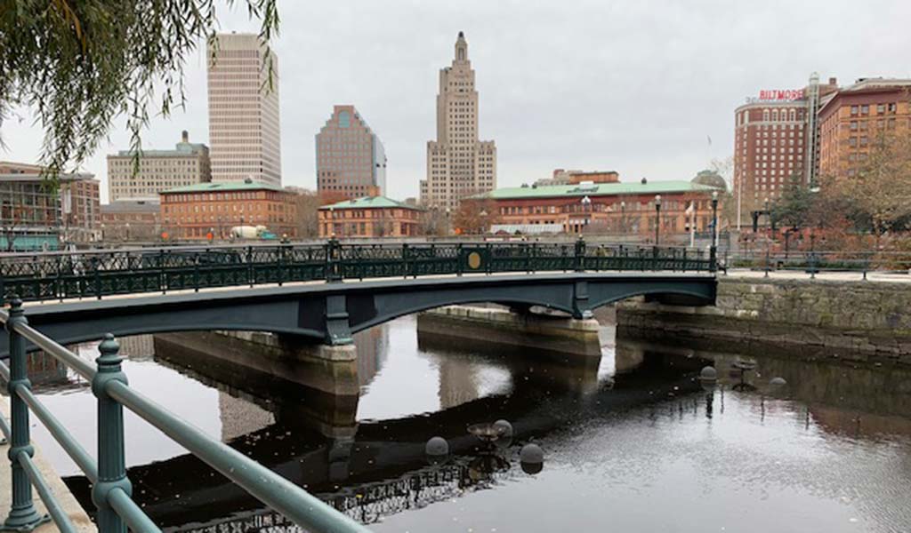 A bridge over a river in downtown Providence with city buildings in background.