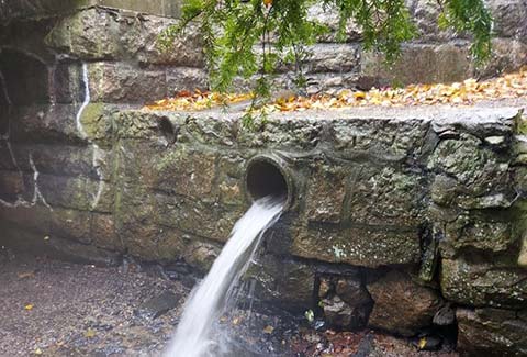 Water pouring out of a stone wall.