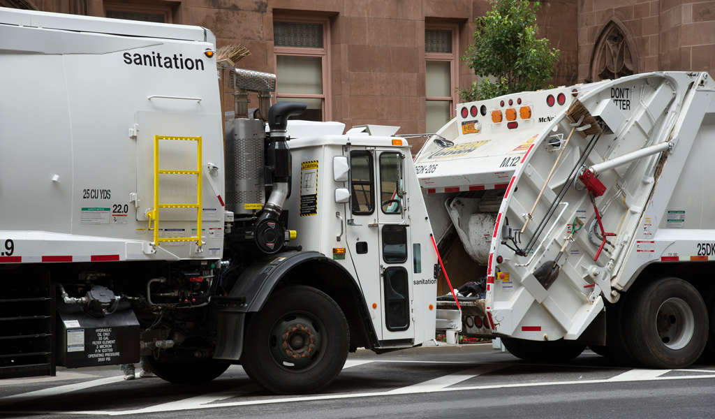 New York City Sanitation white street sweeper on the road. 