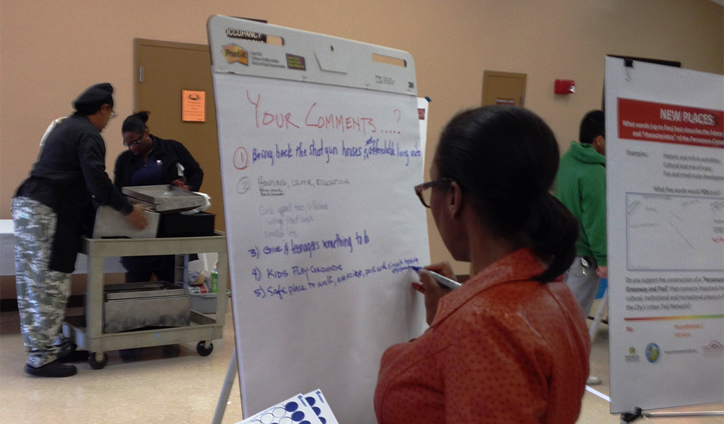 A Woman adds comments to a pad at a community forum.
