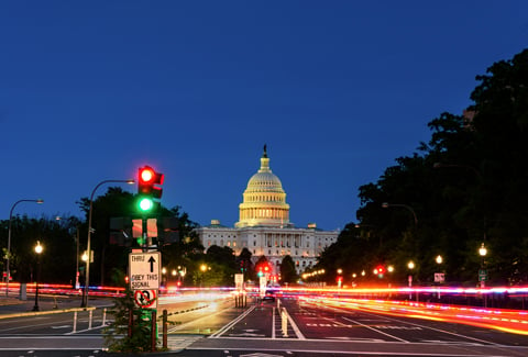 Nighttime view of U.S. Capitol with streetlights.