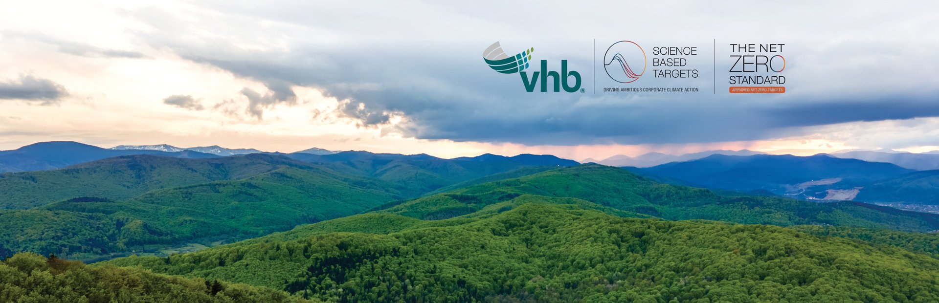 Green mountains in the foreground with the sun setting in the background, with the SBTi logo. 
