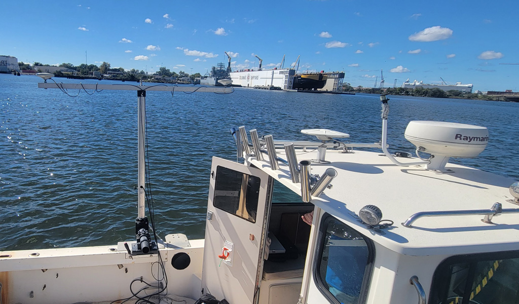 A hydrographic survey beam mounted on the side of a boat in Norfolk Harbor.