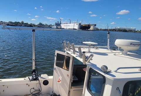 A hydrographic survey beam mounted on the side of a boat in Norfolk Harbor.