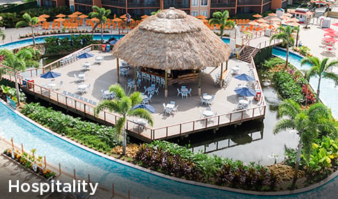 A tiki bar surrounded by a water feature and outdoor patio dining