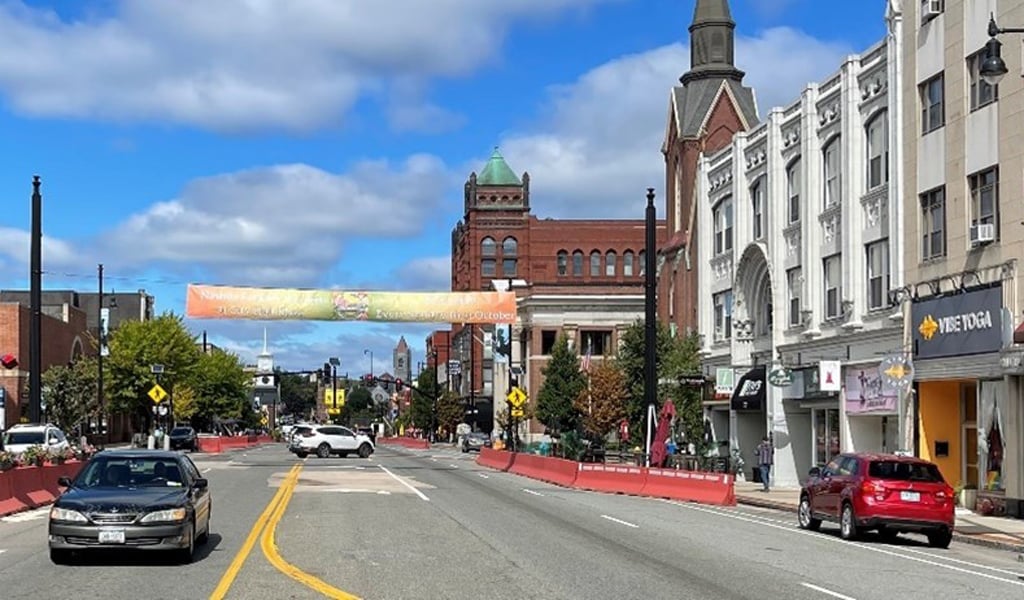 View of a vibrant main street area featuring historic buildings and cars under a clear blue sky.
