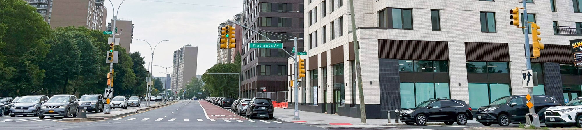 Roadways with cars on street and housing buildings.