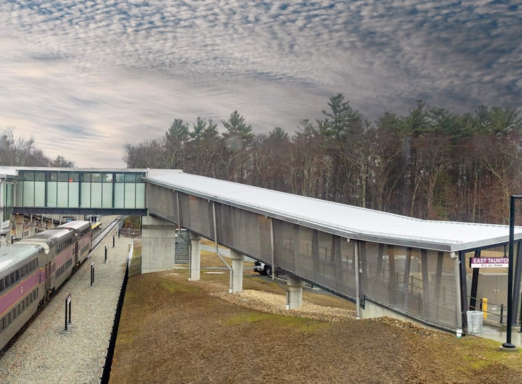 A covered pedestrian bridge and train station.