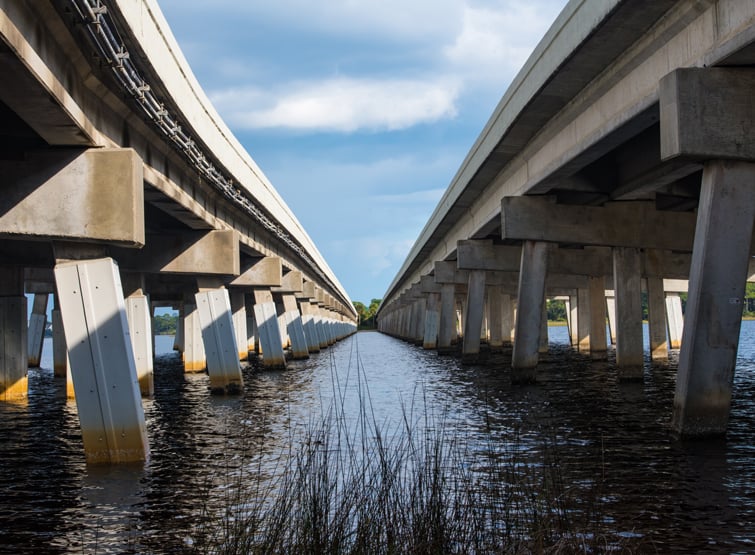 View from underneath a concrete bridge that spans a river