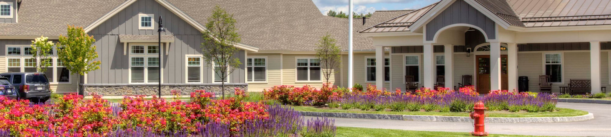 Assisted living facility with colorful flower gardens in front.