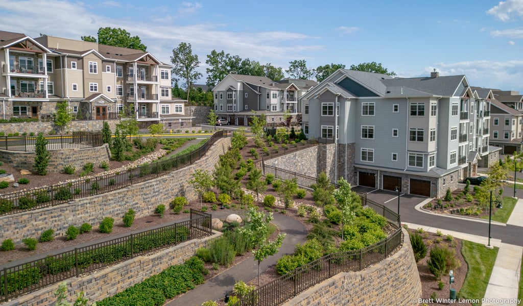 Senior living residences set against a terraced landscape depicting rock walls and accessible pathways. 