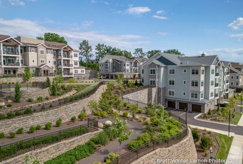 Senior living residences set against a terraced landscape depicting rock walls and accessible pathways. 