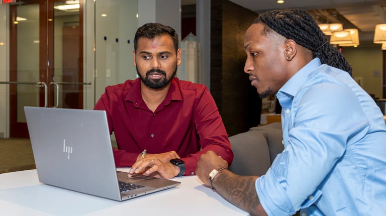 Members of the traffic team have a discussion around a laptop.