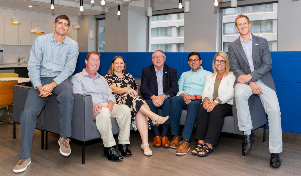 Charlotte leadership team members sit together on a gray couch.