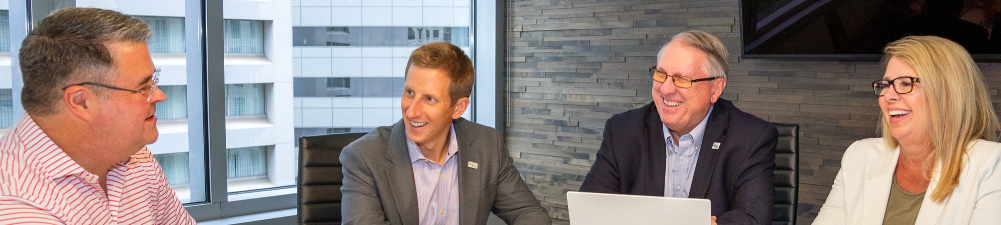 The multimodal planning & design team laugh together around a conference table.