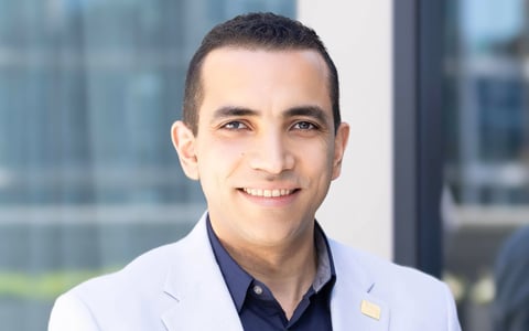 Ahmed Amer smiles at the camera. 