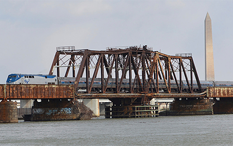  Amtrak Train Crossing over Long Bridge with the Washington Monument in the background.