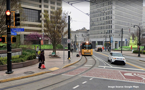 A street car, auto, and pedestrian converge at a busy intersection in Downtown Atlanta  