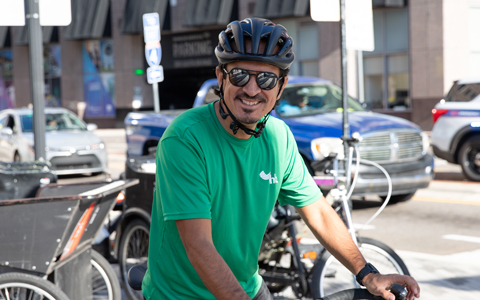 Jaime Igua wears a green VHB shirt and bike helmet.