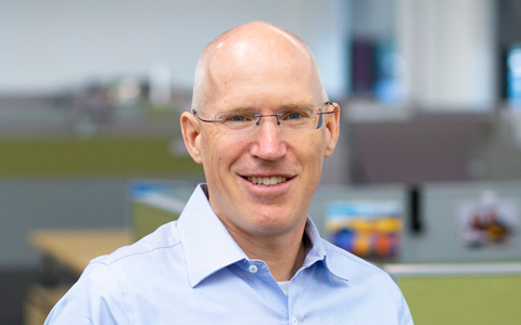 Greg Bosworth smiling in an office setting.