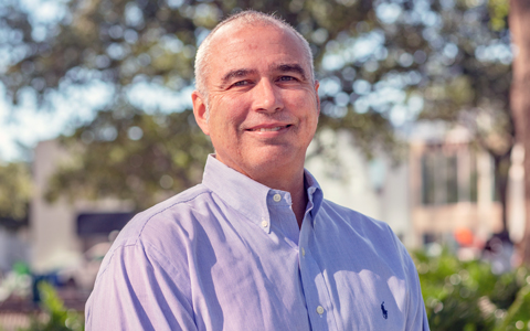 Chris Dailey wears a blue shirt in an outdoor setting.