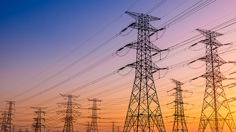 Three transmission towers at sunrise