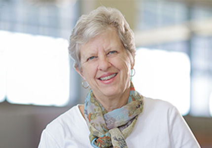 Diane Linderman in colorful scarf and white blouse