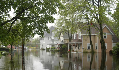 Houses submerged in water on a flooded street in Winchester, Massachusetts.