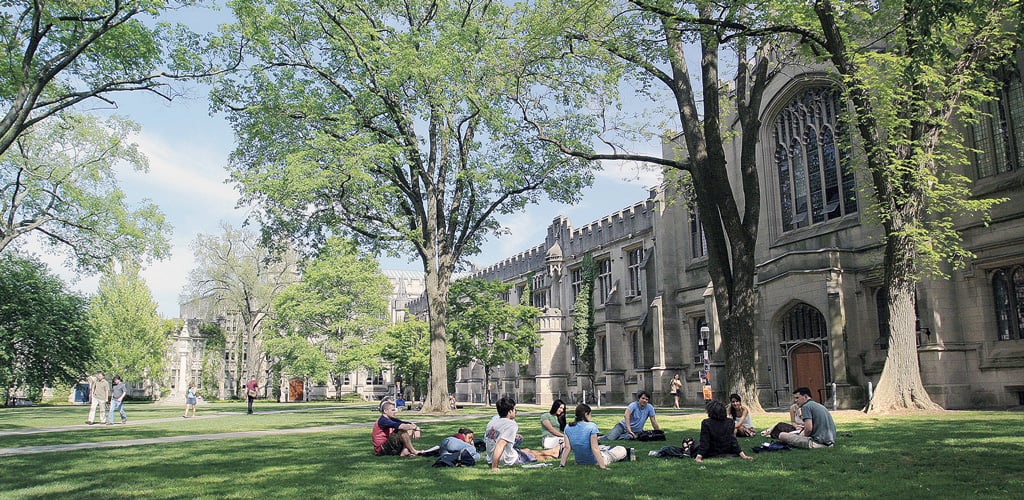 Students sit in the grassy shade on Princeton University’s campus 