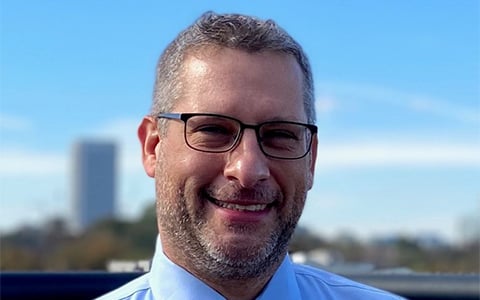 A photo of Jeffrey Goldberg wearing glasses, a tie and a dress shirt.