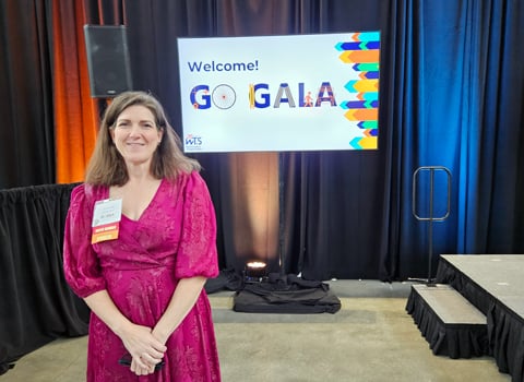 Jenny Fleming smiles at the camera in front of Go Gala sign. 