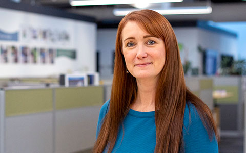 Jessica Strunkin in the office wearing a blue top.