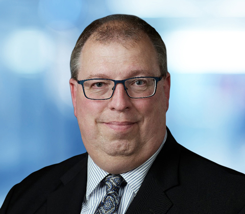 John Thomas wearing a black sports coat and tie.
