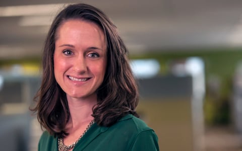 Katie Shannon wears a green shirt in an office setting.