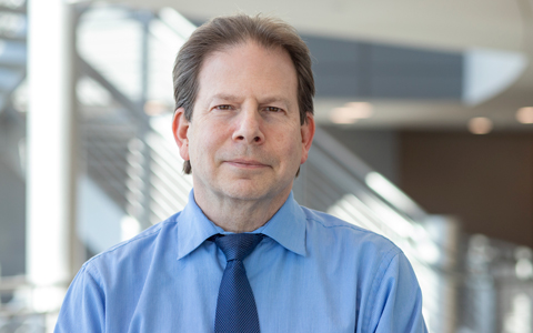 Michael A. Levine in a blue shirt and tie. 