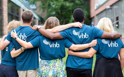 Employees embracing with blue VHB shirts.