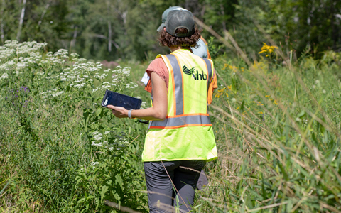 Environmental professional holding a tablet in the field.