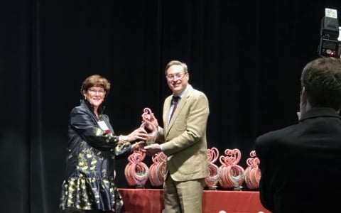 Nancy Barker accepts her Women in Leadership award on stage.