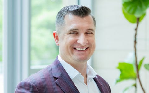 Piotr smiles at the camera.