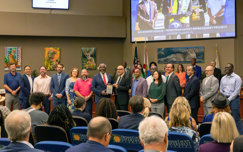 he VHB team stands alongside Mayor Demings in a formal pose.