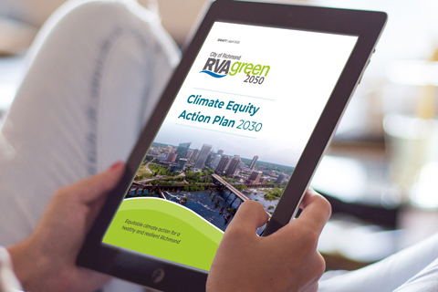 A woman reads the front cover of the Climate Equity Action Plan 2030 on her tablet.