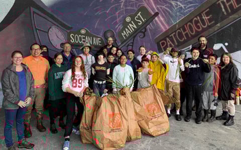 Group of adults and students smiling together.