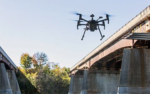 Unmanned aerial vehicle inspecting a bridge
