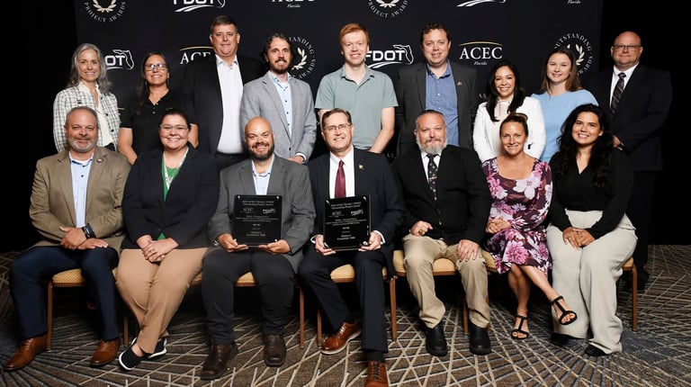 Group of VHB team members pose with awards at ACEC Florida event in front of branded backdrop for PD&E Project recognition.