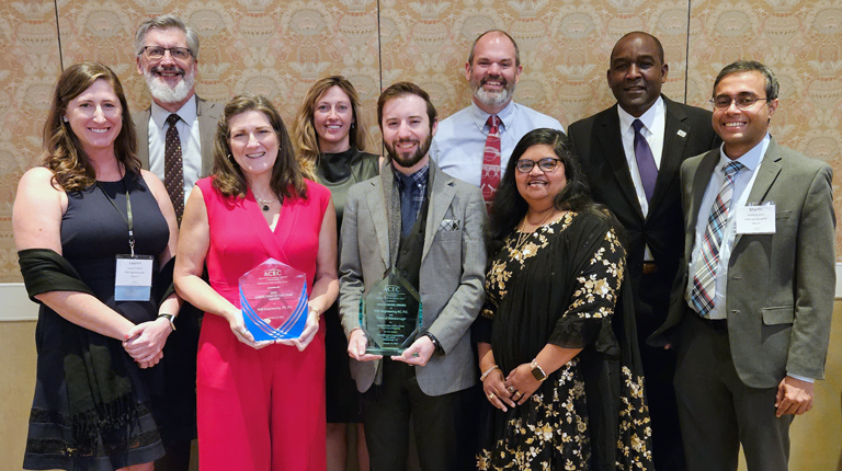 A group of VHBers smile at the camera in a group photo with the awards at the ACEC/NC Awards Gala. 