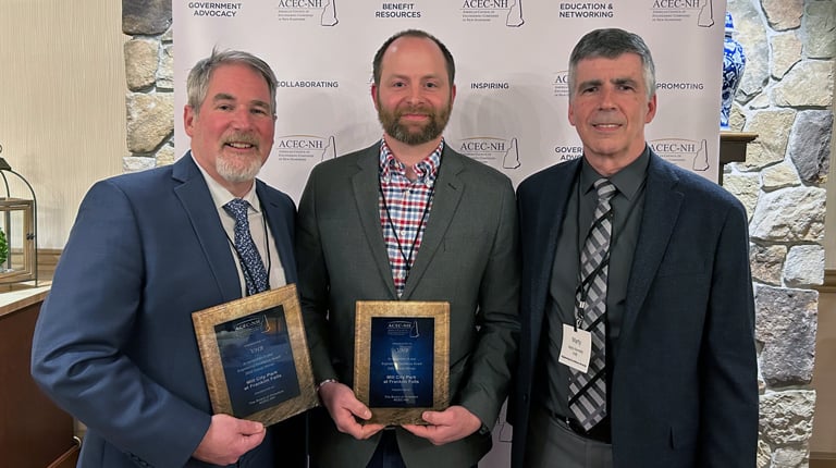 Three men posing with award plaques.