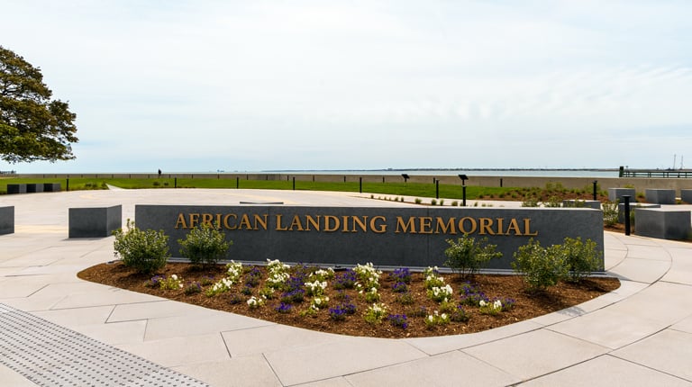 Stone marker reading “African Landing Memorial” set within a circular plaza overlooking the Chesapeake Bay at Fort Monroe.